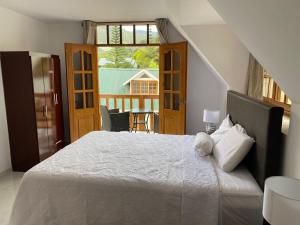 a bedroom with a large bed and a balcony at Hahn des Felsens in Oxapampa +49 photos