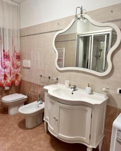a bathroom with a sink and a toilet and a mirror at Appartamenti Estivi in Cirò Marina +57 photos