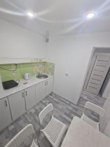 a room with a table and chairs and a kitchen at 1-комнатная квартир в центре города Strekoza in Petropavlovsk