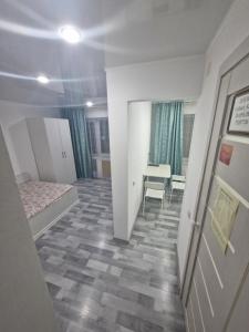 a small room with a bed and a table at 1-комнатная квартир в центре города Strekoza in Petropavlovsk