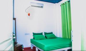 een kamer met een groen bed en een groen gordijn bij Dhanashi Villa Talalla in Talalla South