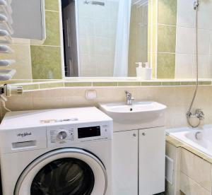 a bathroom with a washing machine and a sink at Meander Natolin Pokoje Blisko Metra in Warsaw