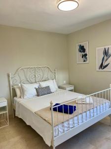 Un dormitorio con una gran cama blanca con almohadas. en Villa Saona Golf, en San Miguel de Abona