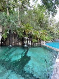 a pool of blue water with trees in the background at Rancho El Venado Termales in Acatic