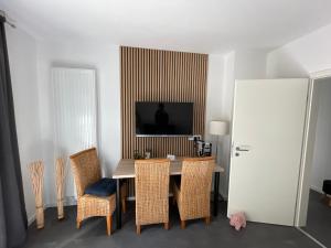a dining room with a table and chairs and a television at Pension Braun - Dein Ankerplatz in Löhne