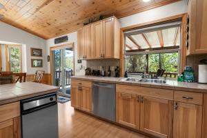 a kitchen with wooden cabinets and a large window at Sugarbear Cabin - Luxurious Log Cabin, Pet Friendly in Sugarloaf