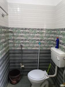 a bathroom with a white toilet in a room at Blueberry Homestay in Guwahati