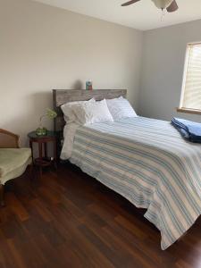 a bedroom with a bed with a striped comforter at Close to the Bozeman airport in Belgrade