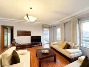 un soggiorno con un divano e una TV di Cozy Apartment Near the Pyramid, Tirana Center a Tirana