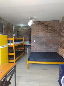 a room with two bunk beds and a brick wall at kitinetes Atômico in Torres