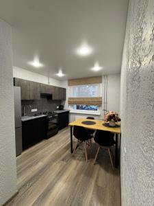 a kitchen with a table and chairs in it at Taikos apartamentas in Mažeikiai
