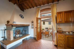 a kitchen with a fireplace and a dining room at AMORE RENTALS - Villa Il Casello in Greve in Chianti