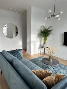 a living room with a blue couch and a mirror at Šiauliai CENTER Višinskio NEW self check In in Šiauliai