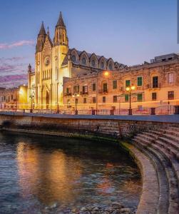 a bridge over a river in front of a building at Lovely room near Balluta Bay RB in San Ġwann