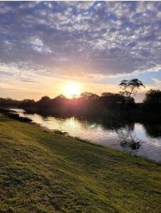 una puesta de sol sobre un río con la puesta de sol en Cabañas "Mainimbu" 2, en General Belgrano
