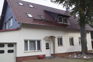 a white house with a red roof at FEWO Thüringer Becken in Sömmerda