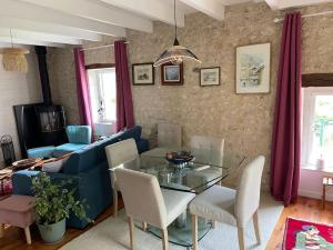 een woonkamer met een blauwe bank en een glazen tafel bij Chez Miquelot in Saint-Martial