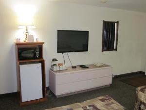 een woonkamer met een flatscreen-tv op een dressoir bij Chinook Motel in Lethbridge