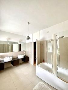 a bathroom with two sinks and a tub and a shower at Nuovo Progetto A&E in Vicenza