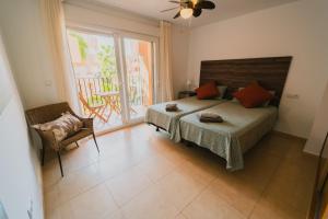 a bedroom with a bed and a chair and a window at Bonsai in Murcia