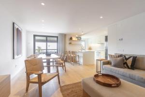 un soggiorno e una cucina con un divano e un tavolo di Oceanfront Lux Condo Sleeps 9 a Cascais