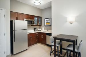 a kitchen with a refrigerator and a table and chairs at Residence Inn by Marriott Fort Lauderdale City of Plantation in Plantation