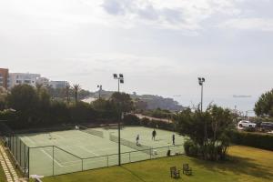 2 persone che giocano a tennis su un campo da tennis di Oceanfront Lux Condo Sleeps 9 a Cascais