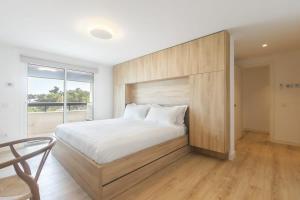 una camera da letto con un letto grande con testiera in legno di Oceanfront Lux Condo Sleeps 9 a Cascais Altre 58 foto