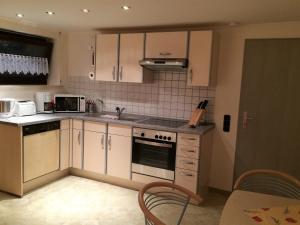 cocina con armarios blancos y fogones en Ferienwohnung-Lind, en Wimbach