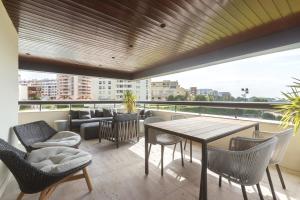 un balcone con tavolo, sedie e divano di Oceanfront Lux Condo Sleeps 9 a Cascais