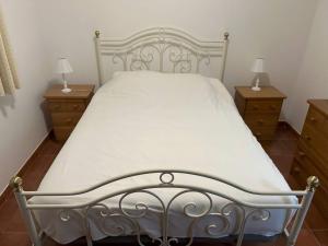 a white bed with two night stands and two lamps at Villa Vona - private pool, beautiful garden in 3 BDR villa in Óbidos +15 photos