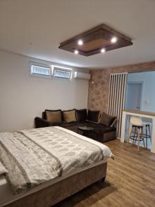 a bedroom with a bed and a couch at Apartmani Pejovic in Nikšić +15 photos