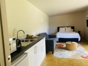 a kitchen with a sink and a room with a bed at Highlander Farmstay - Cabins in Whangarei