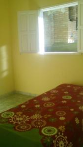 Schlafzimmer mit einem roten Bett und einem Fenster in der Unterkunft Casa no Centro de Ibitipoca in Conceição da Ibitipoca