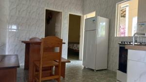 eine Küche mit einem weißen Kühlschrank und einem Holzstuhl in der Unterkunft Casa no Centro de Ibitipoca in Conceição da Ibitipoca