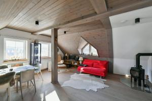 a living room with a red couch and a table at Apartmán v srdci Krkonoš in Horní Maršov