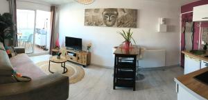a living room with a couch and a tv at La Perle Marine, Cosy et rénové, 200 m de la plage, 1 chambre, parking et Wifi in Sète