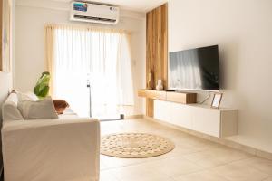 a living room with a television and a white couch at Arrayanes 5 B in San Miguel de Tucumán