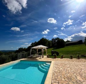 a swimming pool with a gazebo next to a field at Collepetrucci in Ciciano