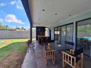 a patio with a table and chairs and a television at Muana Escobar in Belén de Escobar
