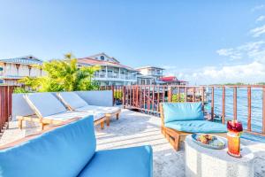 un patio con 2 sillas y una mesa con vistas al agua en Tropical Suites Hotel, en Bocas Town