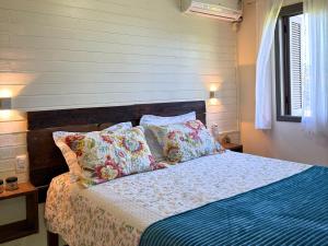 a bedroom with a bed with pillows on it at Pousada da Baronesa in Nova Petrópolis