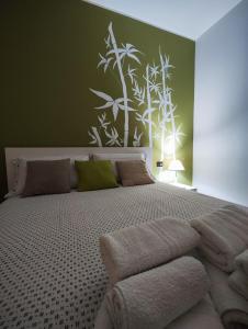 a bedroom with a large bed with green walls at il Bamboo 1 in Taranto +6 photos
