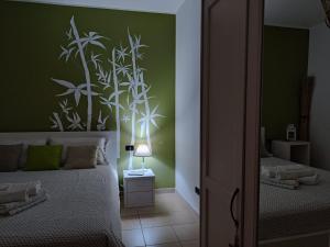 a bedroom with a bed with a green wall at il Bamboo 1 in Taranto