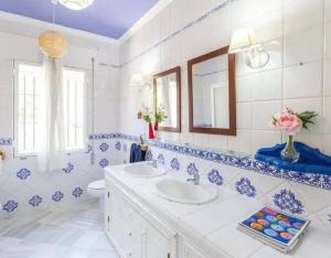 een blauwe en witte badkamer met een wastafel en een spiegel bij Charming house in Arcos with private pool in Arcos de la Frontera +10 foto's