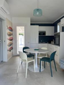 a kitchen with a table and chairs in a kitchen at Villa Mar Mediterraneo in Villasimius