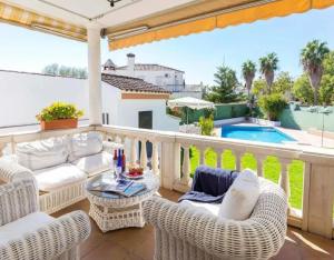 een patio met rieten stoelen, een tafel en een zwembad bij Charming house in Arcos with private pool in Arcos de la Frontera