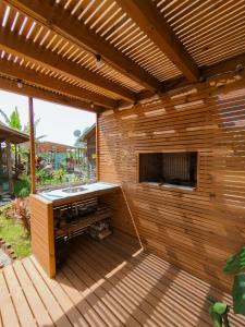 un patio de madera con un fregadero en una terraza de madera en Cabanas MORIÁ, en Garopaba