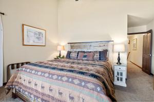 a bedroom with a bed and two lamps in it at Shores Lakefront Condo - Walk to Village, Lake Views, Deck with BBQ in Big Bear Lake