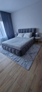a large bed in a bedroom with a rug at Free SPA Pirin lodge cosy apartment in Bansko